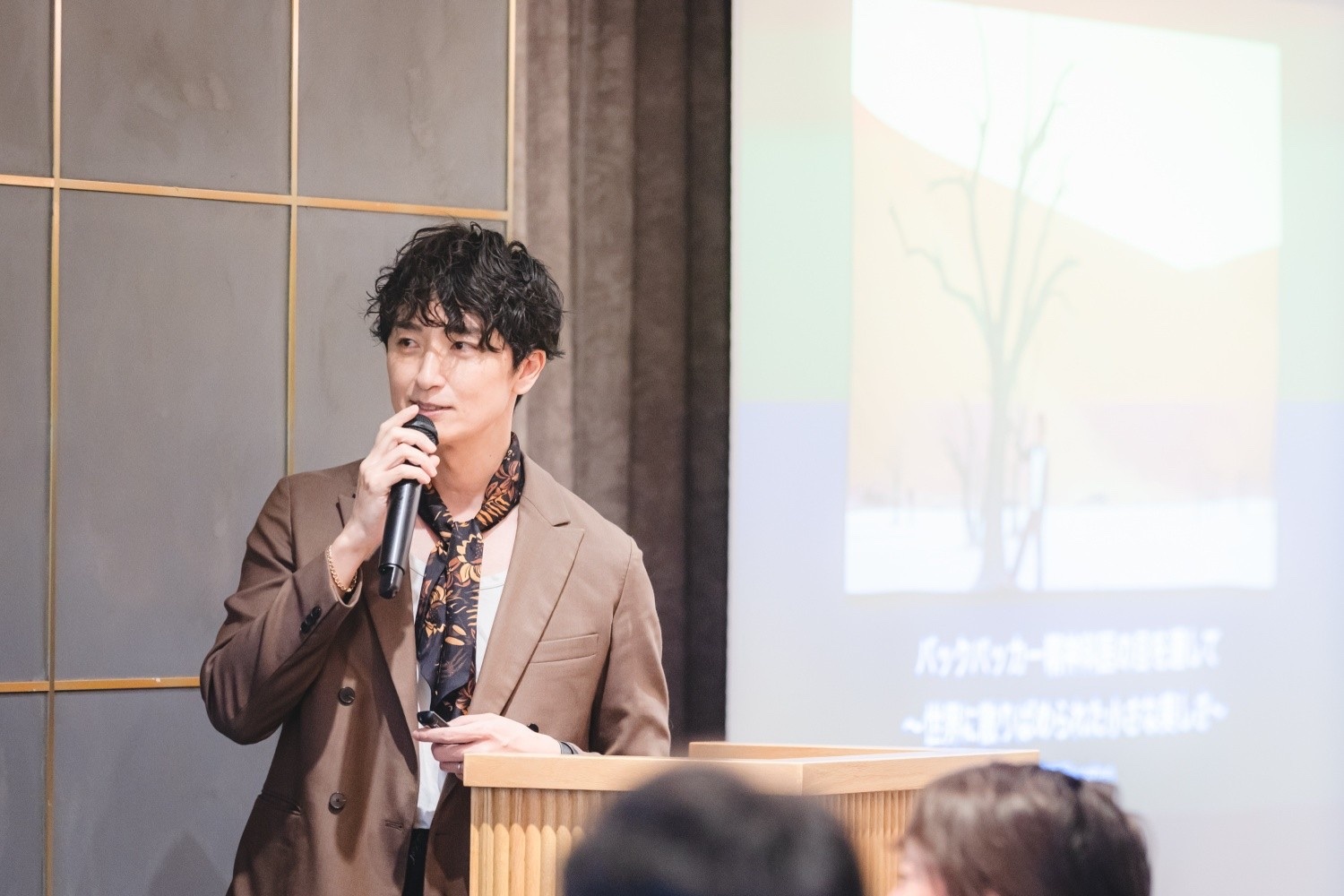講演でマイクを持って話す加賀谷隼輔